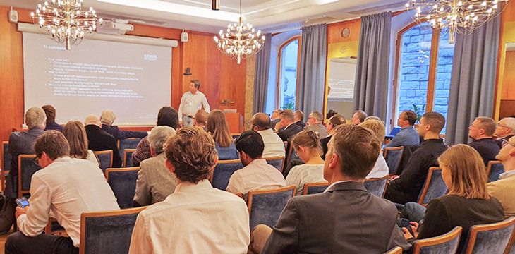 En grupp människor som sitter på stolar framför en projektorskärm.