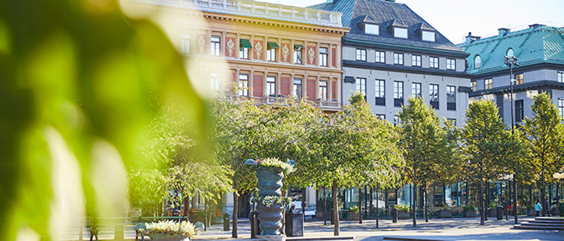 En utsikt över ett stadstorg med en fontän i förgrunden.